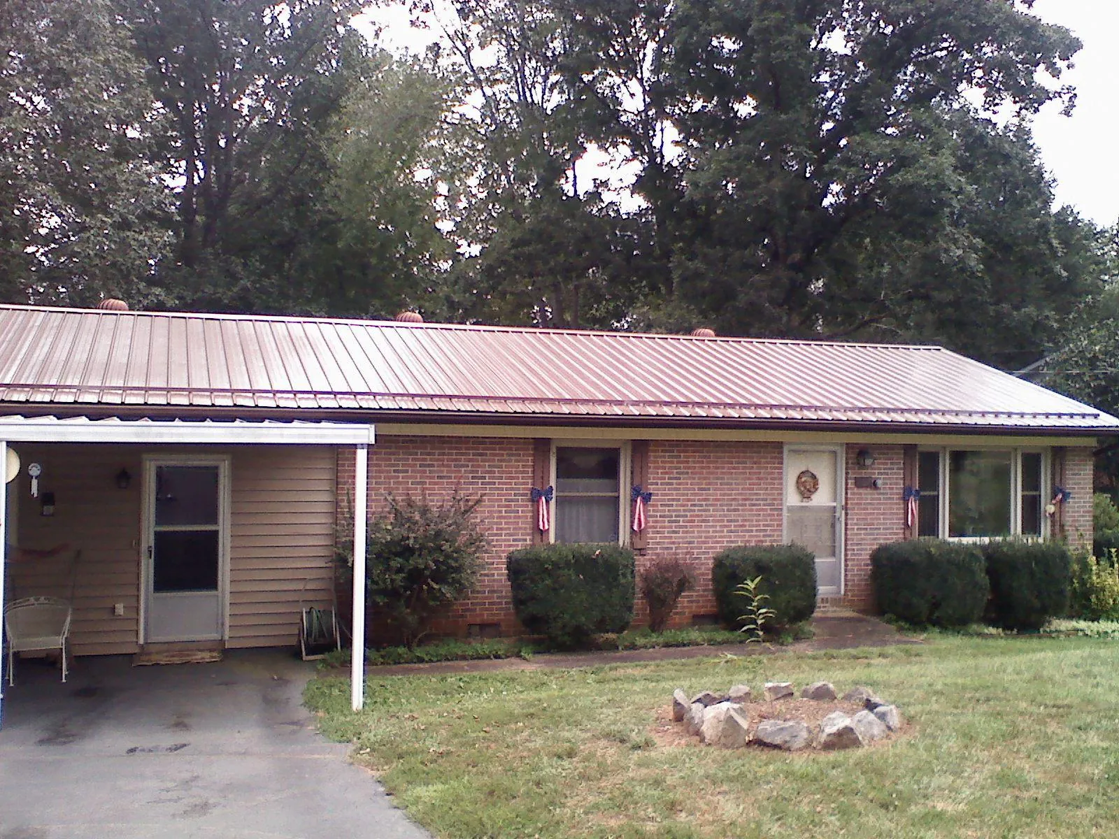 Bronze metal roof and carport on a brick ranch home — Roof Repair work by our crew in Pittsburg