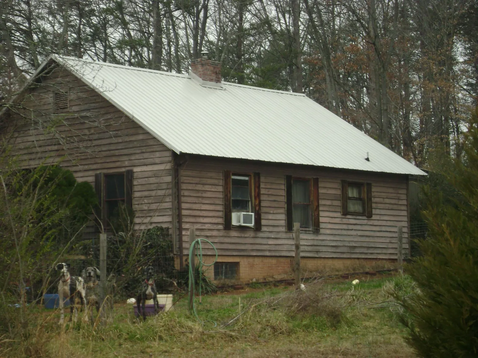 White metal roof on an old wood sided farmhouse, from a Asphalt Shingle Roof Repair job in Pittsburg